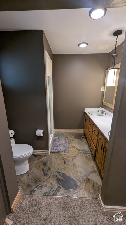 Full bathroom featuring vanity, stone finish flooring, and a stall shower