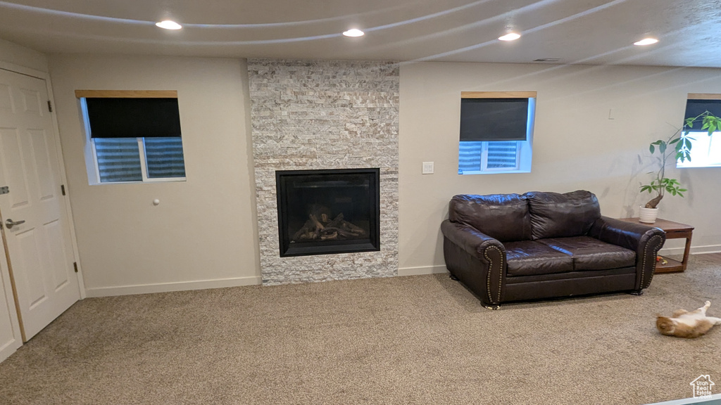 Living room featuring carpet flooring, recessed lighting, and a fireplace