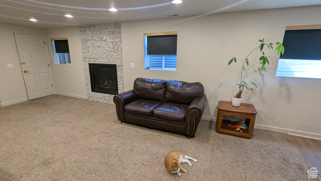Carpeted living room with recessed lighting and a fireplace