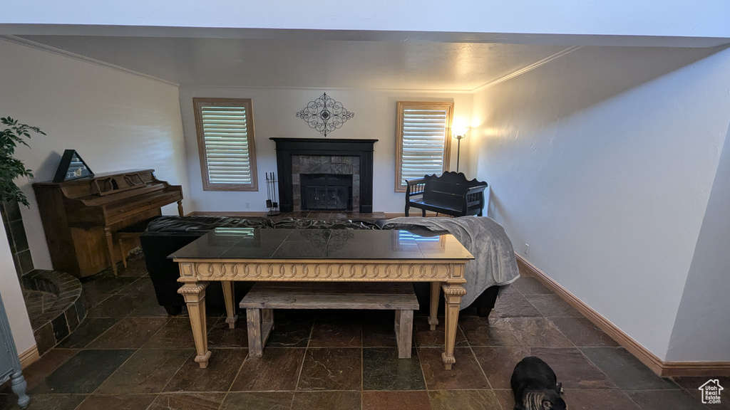 Dining room featuring stone tile flooring, ornamental molding, and a fireplace