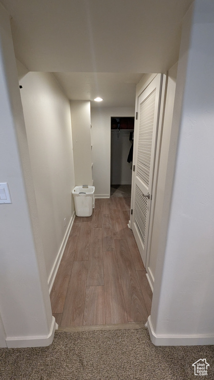 Corridor with wood finished floors and recessed lighting