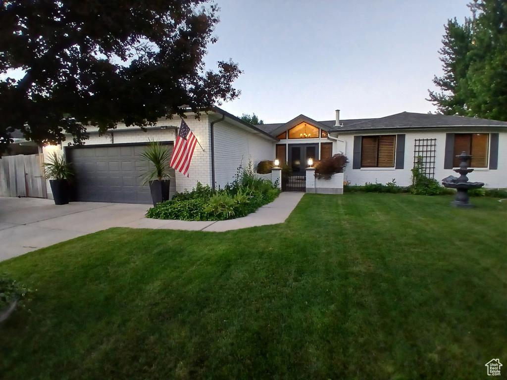 View of front facade with concrete driveway, an attached garage, and brick siding