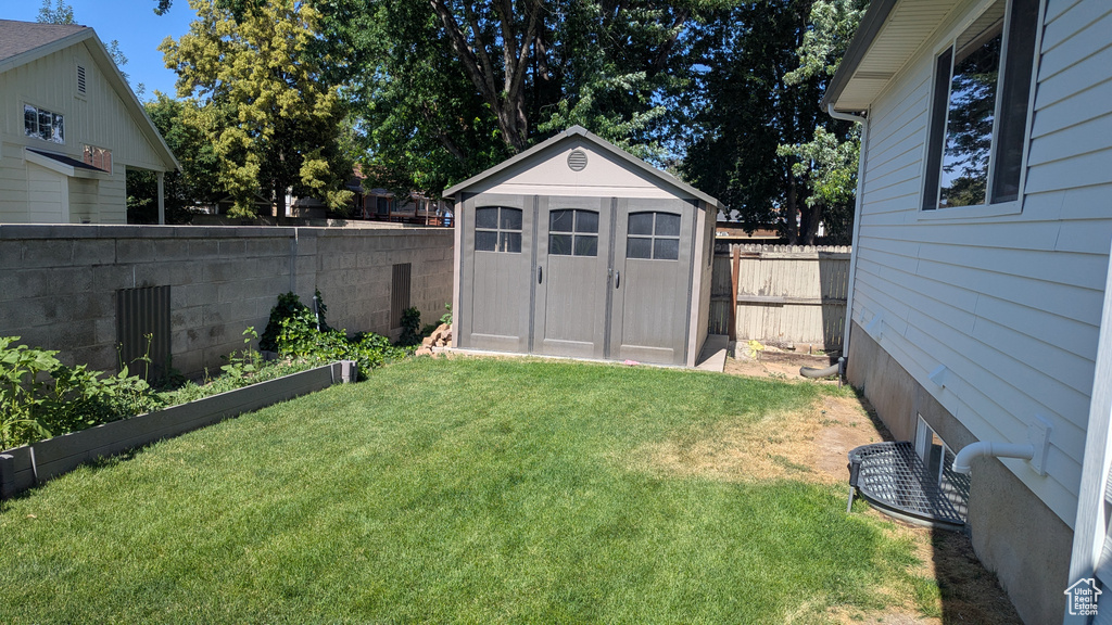 Fenced backyard featuring a storage shed