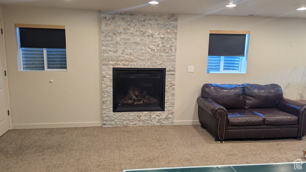 Living room featuring carpet, recessed lighting, and a stone fireplace