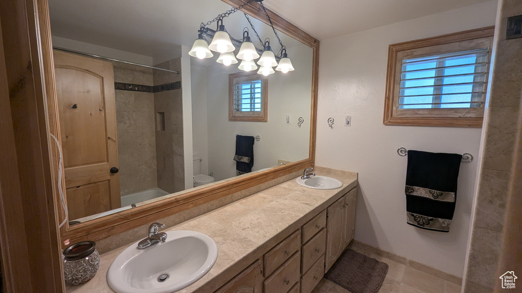 Full bathroom with plenty of natural light, double vanity,  shower combination, and tile patterned floors