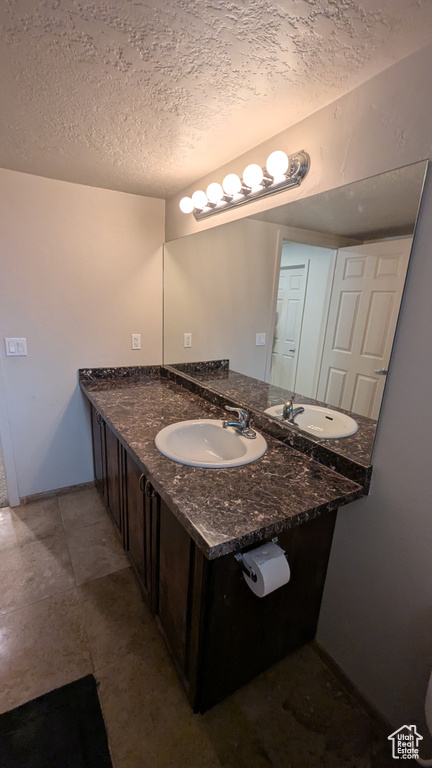 Bathroom with vanity and a textured ceiling