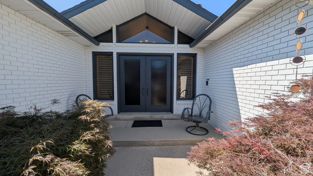 Property entrance featuring french doors and brick siding