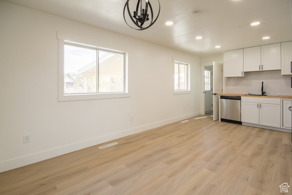 Kitchen with dishwasher, recessed lighting, light wood-type flooring, white cabinets, and a chandelier