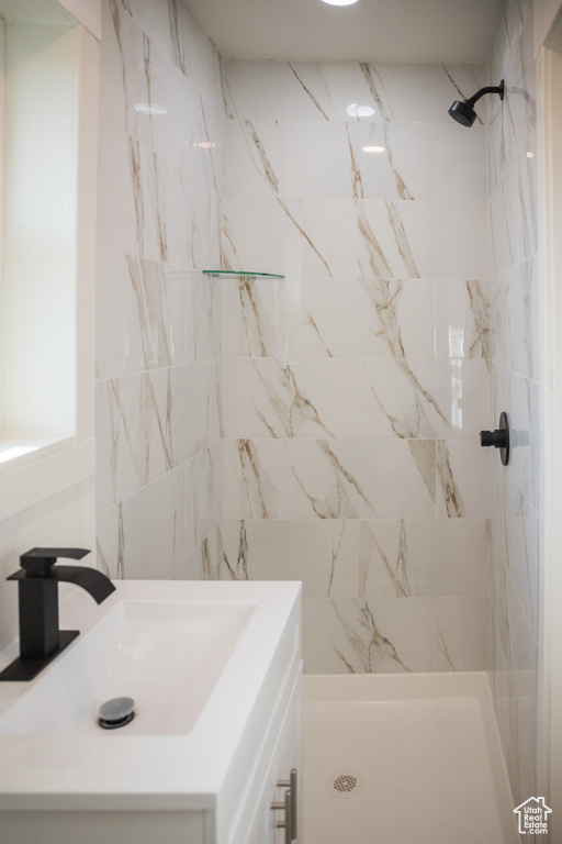 Bathroom with vanity and tiled shower