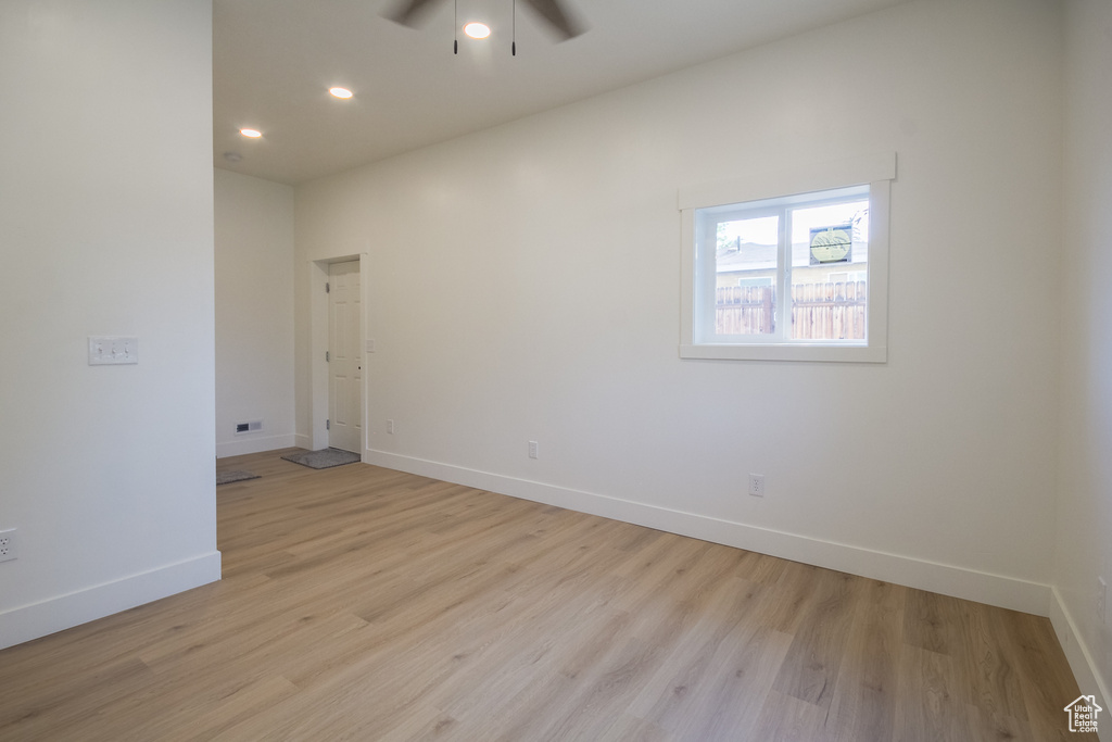 Empty room featuring ceiling fan, light wood-style floors, and recessed lighting