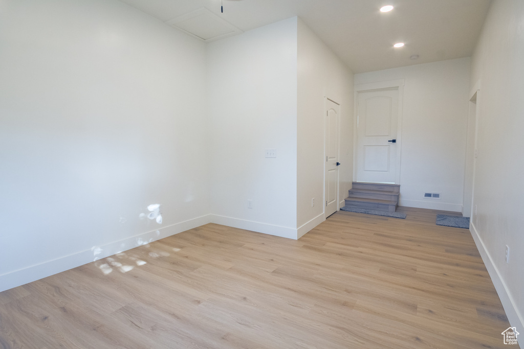 Empty room with light wood-type flooring and recessed lighting