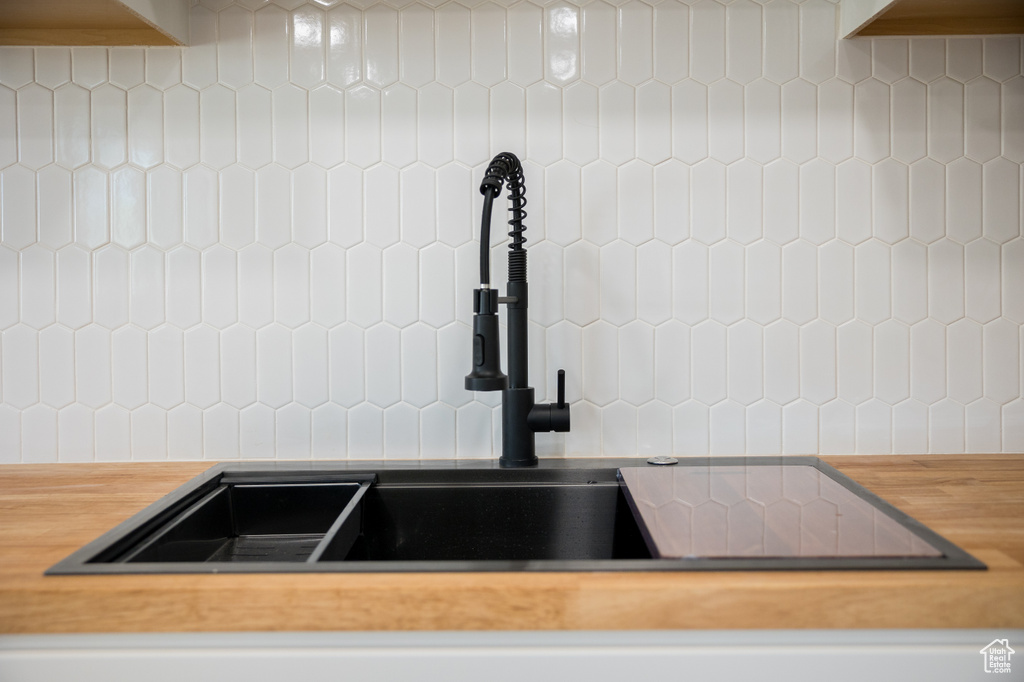 Kitchen view of butcher block counters and tasteful backsplash