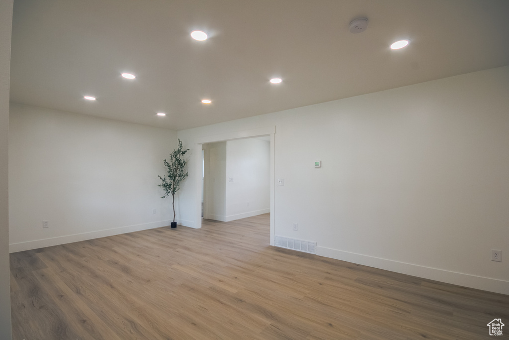 Empty room featuring recessed lighting, light wood-type flooring, and a smoke detector