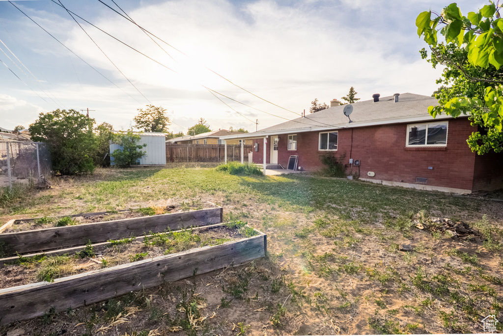 View of yard featuring a vegetable garden and a shed