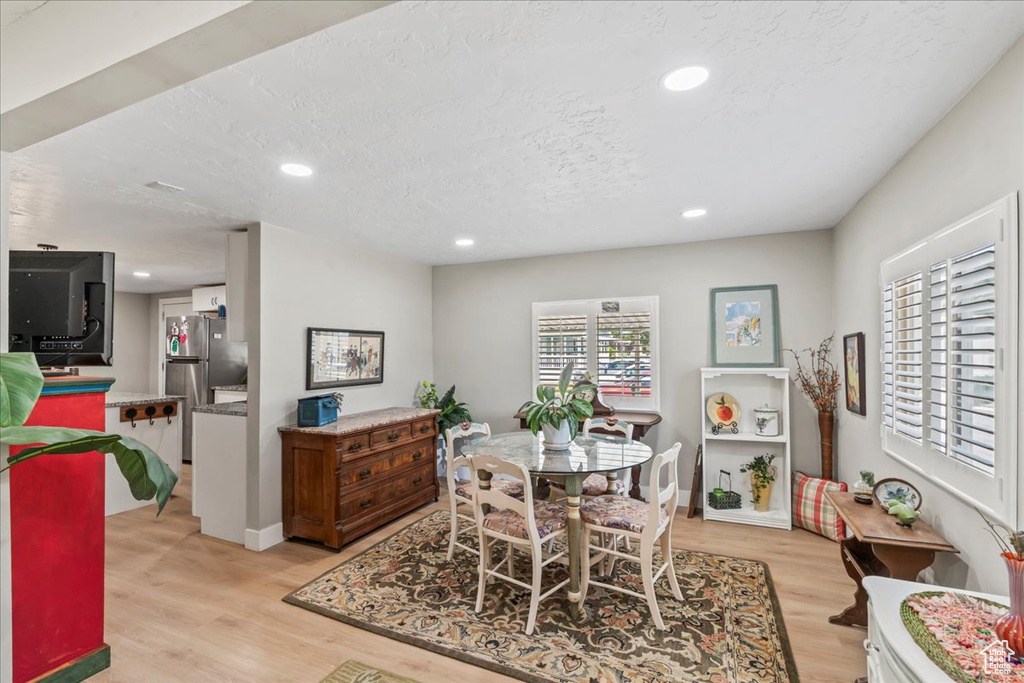 Dining room with light wood-style flooring, recessed lighting, and a textured ceiling