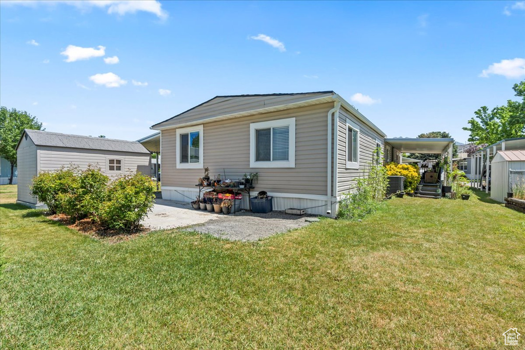 Back of house with a yard and a patio area