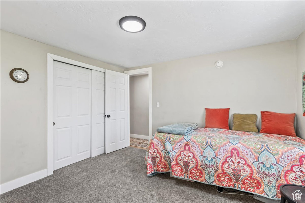 Carpeted bedroom featuring a closet and baseboards