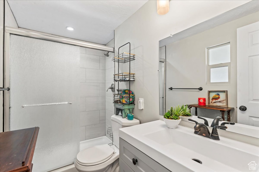 Full bath featuring a tile shower and vanity