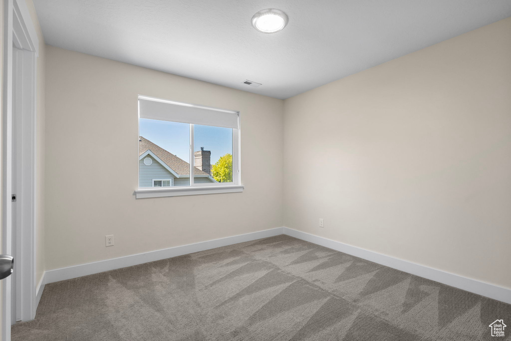 Spare room featuring carpet floors and baseboards