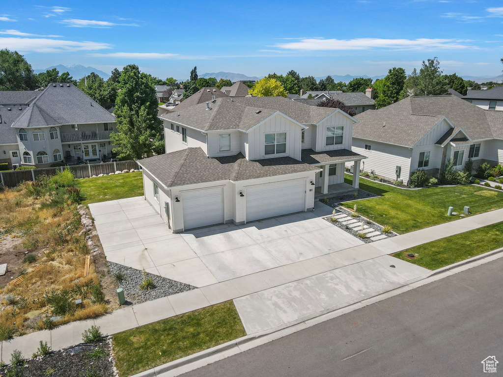 View of front of home with board and batten siding, concrete driveway, a residential view, a shingled roof, and an attached garage
