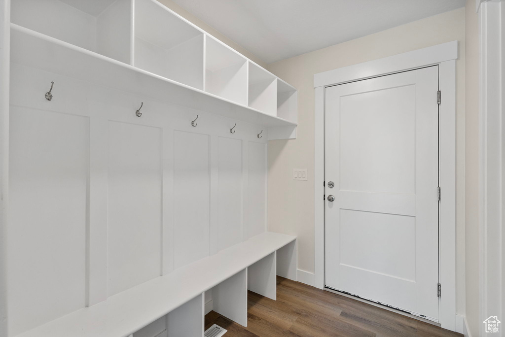 Mudroom featuring dark wood-type flooring and baseboards