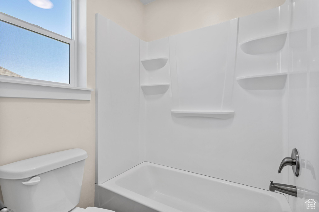 Bathroom featuring toilet and bathing tub / shower combination