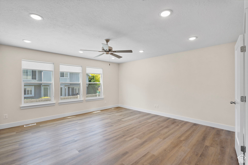 Unfurnished room with a ceiling fan, light wood-type flooring, recessed lighting, and a textured ceiling