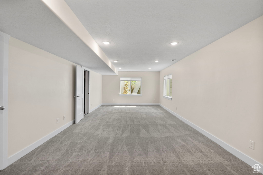 Unfurnished room with light colored carpet and recessed lighting
