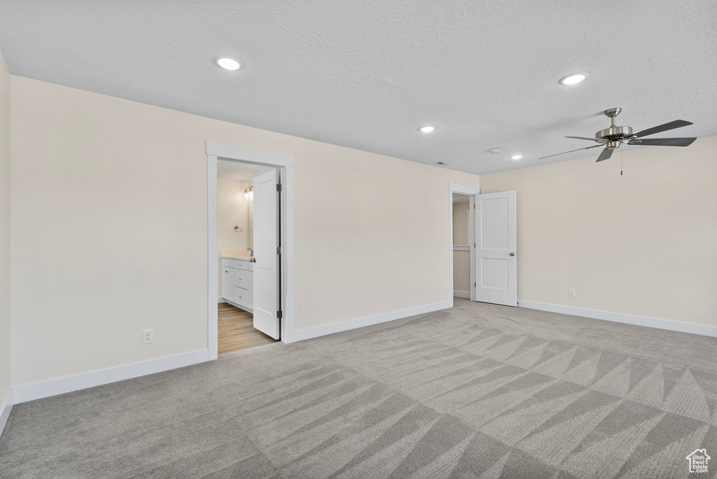 Empty room featuring light colored carpet, recessed lighting, ceiling fan, and a textured ceiling