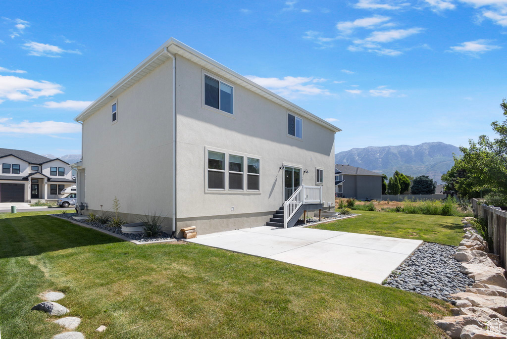 Rear view of property with a patio area, a mountain view, and stucco siding