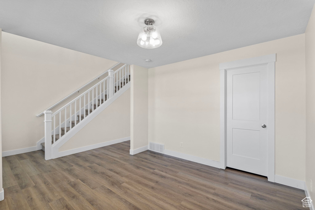 Unfurnished living room with wood finished floors and stairs