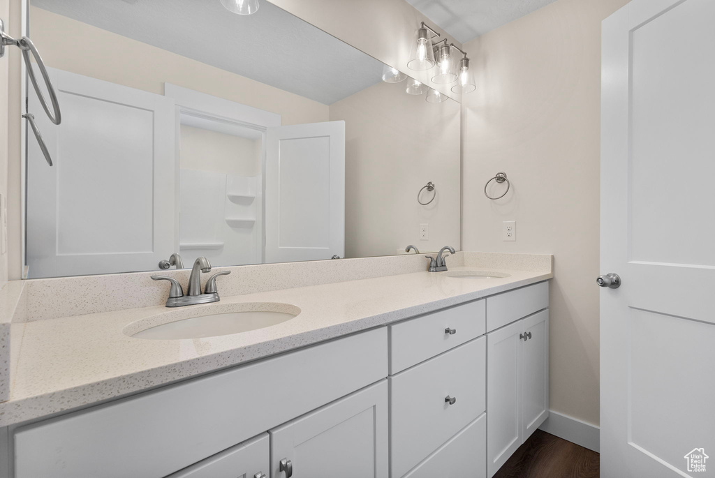 Bathroom featuring double vanity and wood finished floors