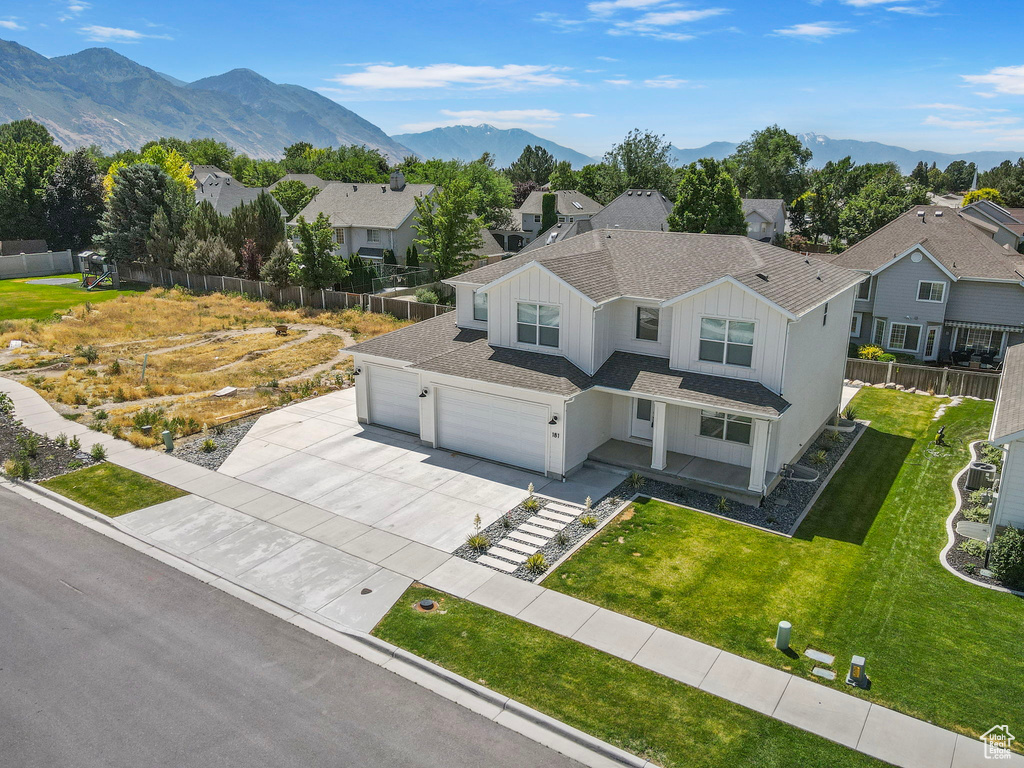 View of front of property with board and batten siding, driveway, a shingled roof, a residential view, and a garage