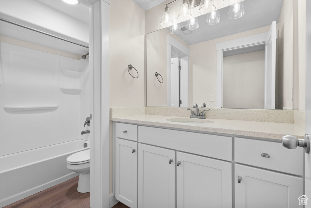 Bathroom with vanity, wood finished floors, and shower / bath combination