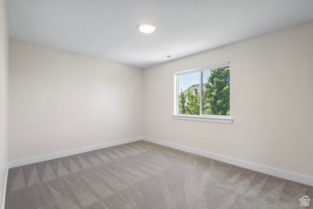Carpeted spare room with baseboards