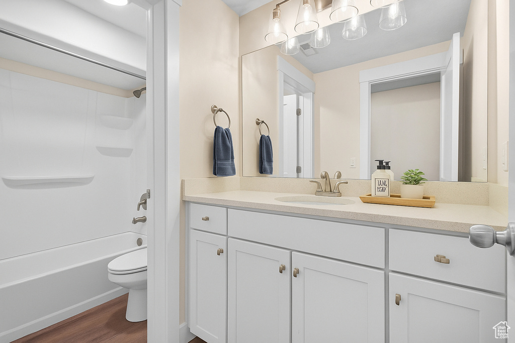 Bathroom with vanity, wood finished floors, and  shower combination