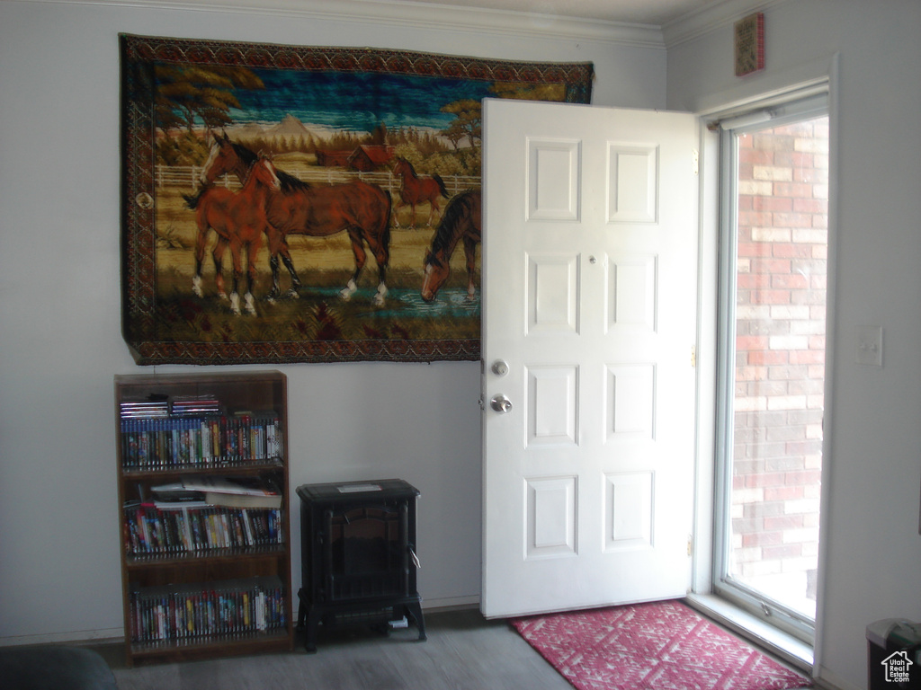 Entryway with crown molding and wood finished floors