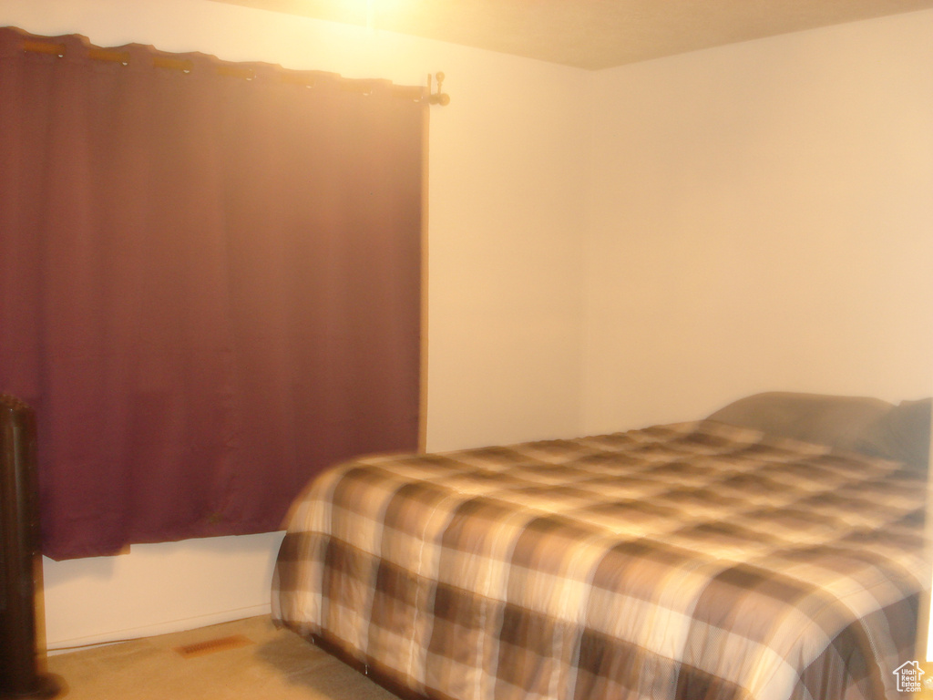 Bedroom featuring light colored carpet
