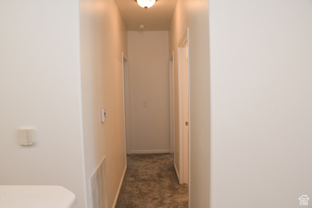 Hall featuring carpet floors and baseboards