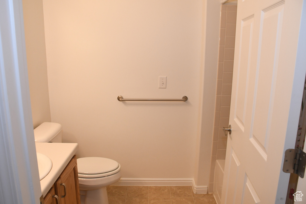 Bathroom with vanity, baseboards, toilet, and tile patterned floors