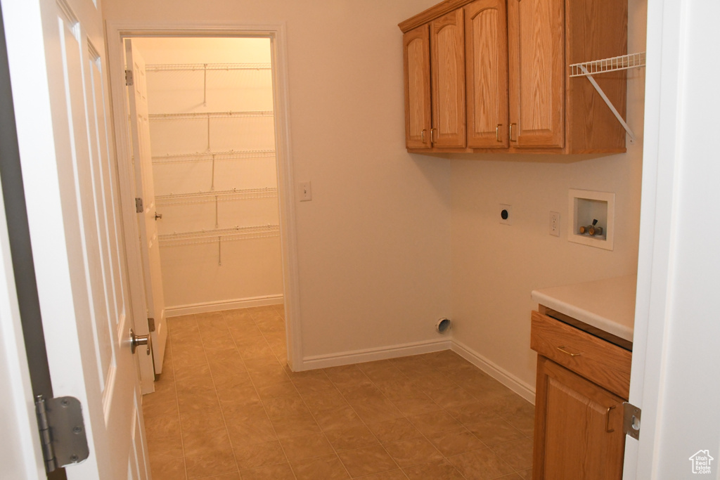Laundry room with hookup for an electric dryer, cabinet space, hookup for a washing machine, and baseboards