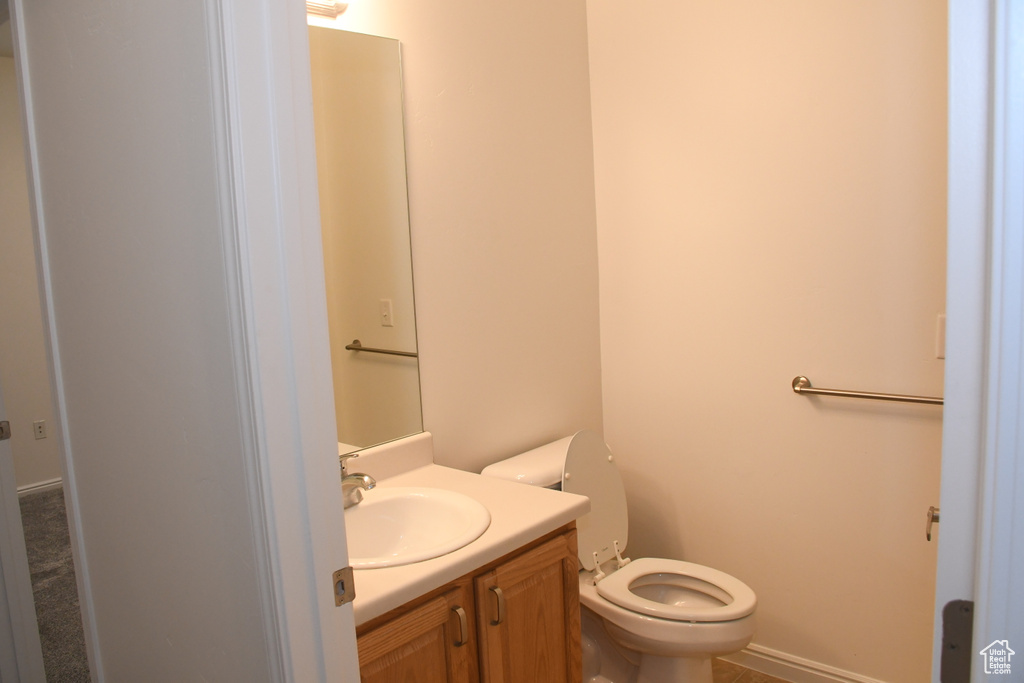 Half bath featuring toilet and vanity