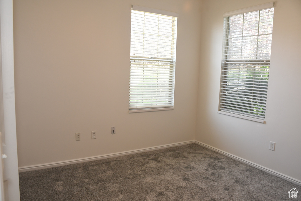 Carpeted spare room featuring baseboards