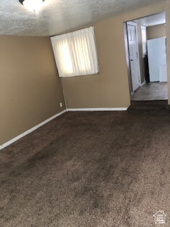 Empty room with carpet and a textured ceiling
