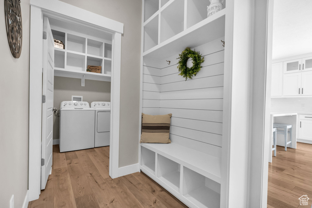 Mudroom with independent washer and dryer and light wood-style flooring