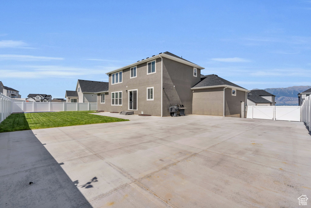 Back of property featuring a gate, a fenced backyard, a patio area, and stucco siding