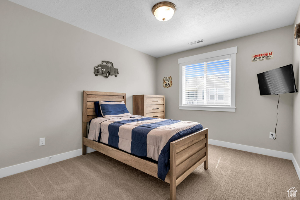 Bedroom with carpet and a textured ceiling