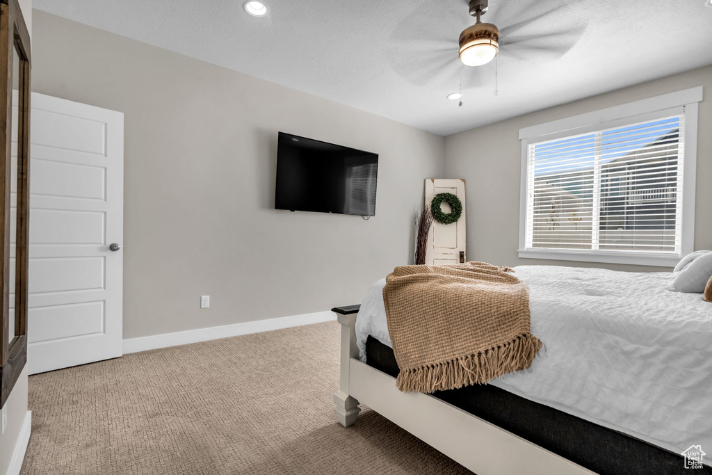 Carpeted bedroom featuring ceiling fan and recessed lighting