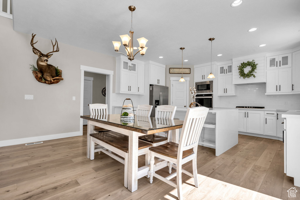 Dining room with a chandelier, light wood-type flooring, and recessed lighting