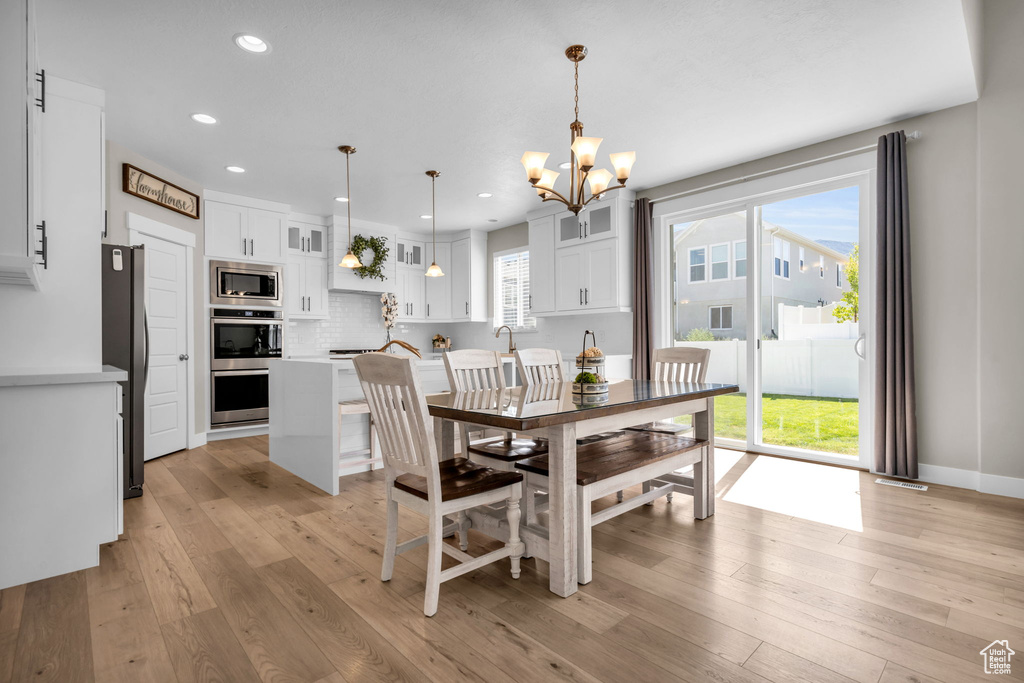 Dining space with a chandelier, recessed lighting, and light wood-style floors
